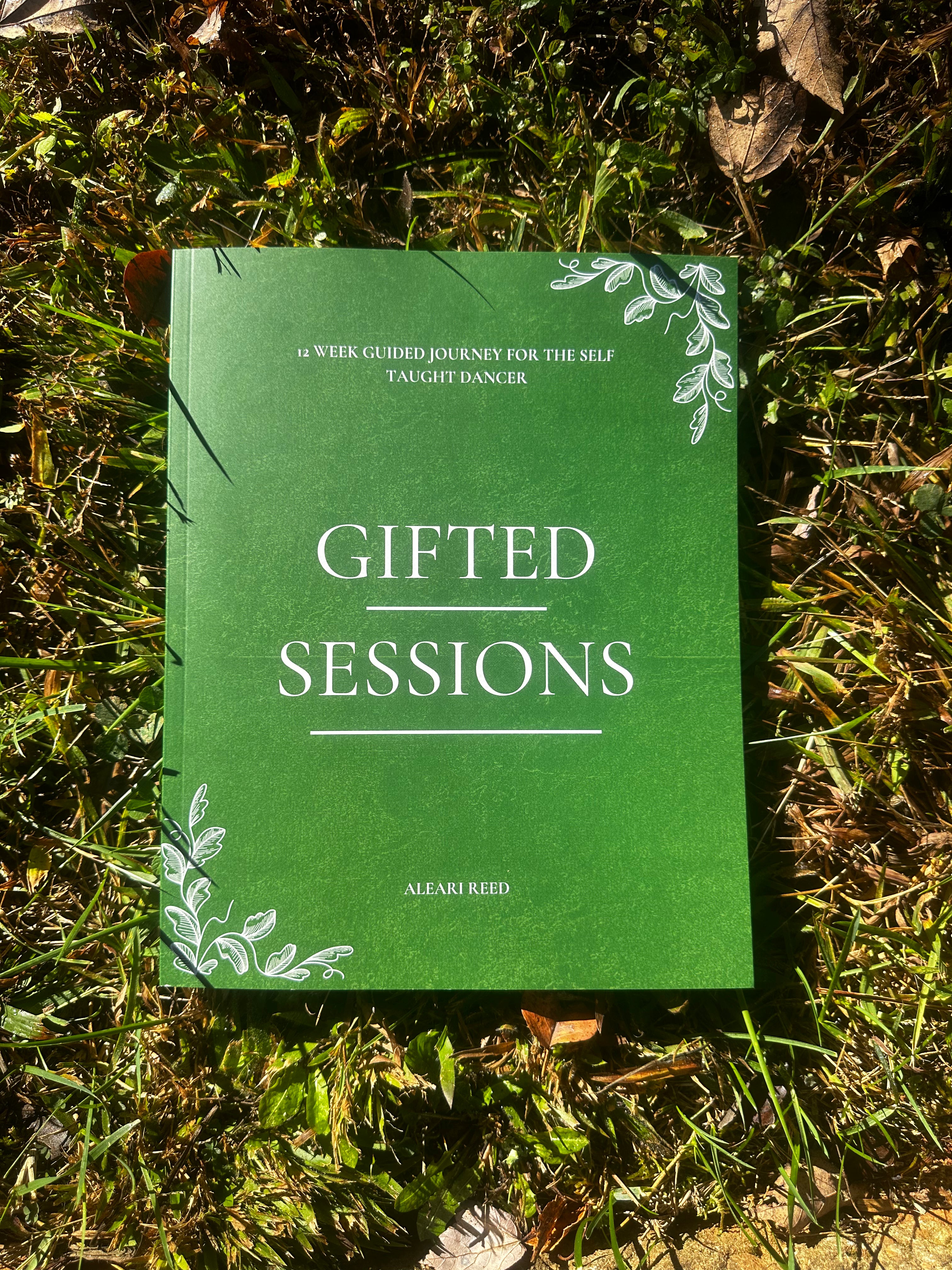 Green book titled 'Gifted Sessions' on grass
